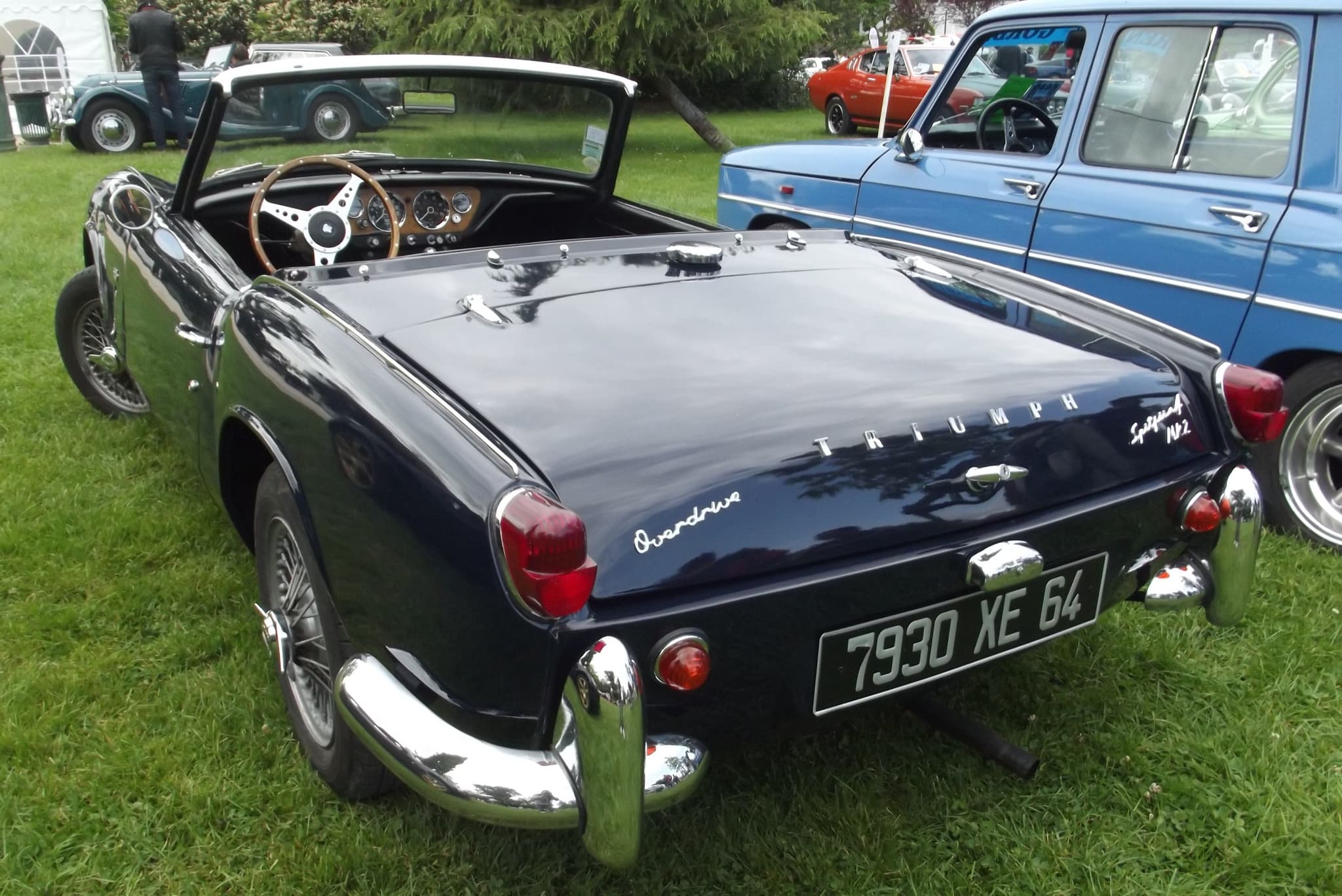 The tail of a dark blue Spitfire 4 Mk II with its Overdrive script, wire wheels and chrome quarter-bumpers.