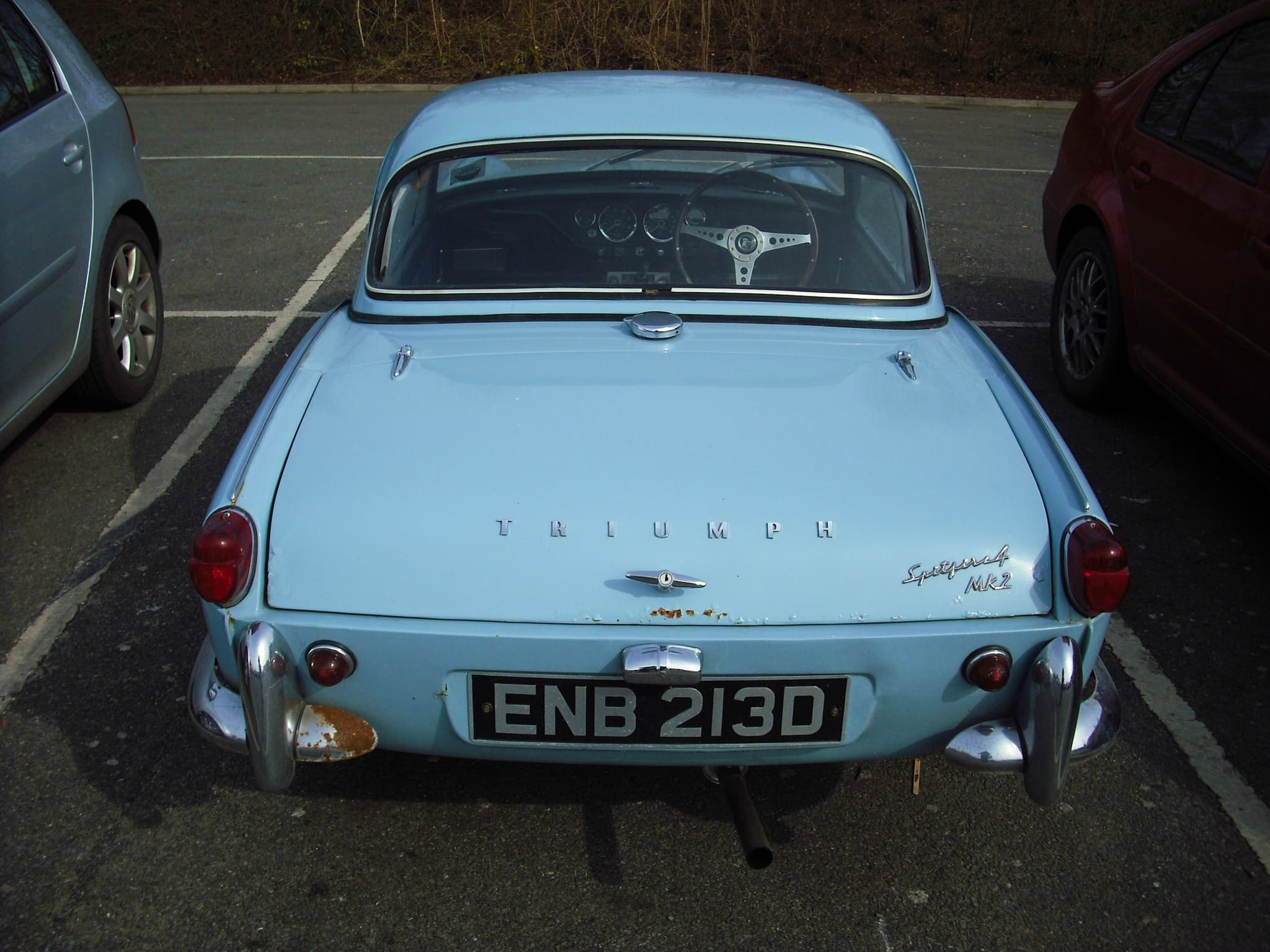 The rear of a pale blue Spitfire 4 Mk II with a hardtop, its boot script and quarter bumpers.